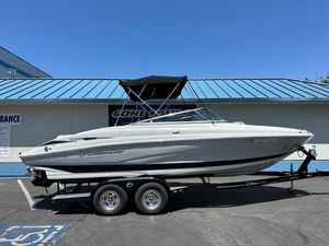 2019 Crownline 235 SS boat on trailer, parked outdoors with blue roof background.