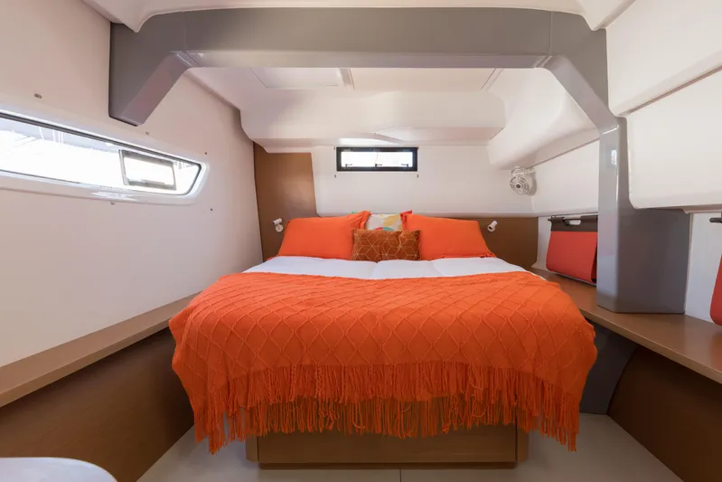 In Stock Yacht Photos Pics Cozy cabin interior of 2024 Excess 14 yacht with orange bedding and modern design.