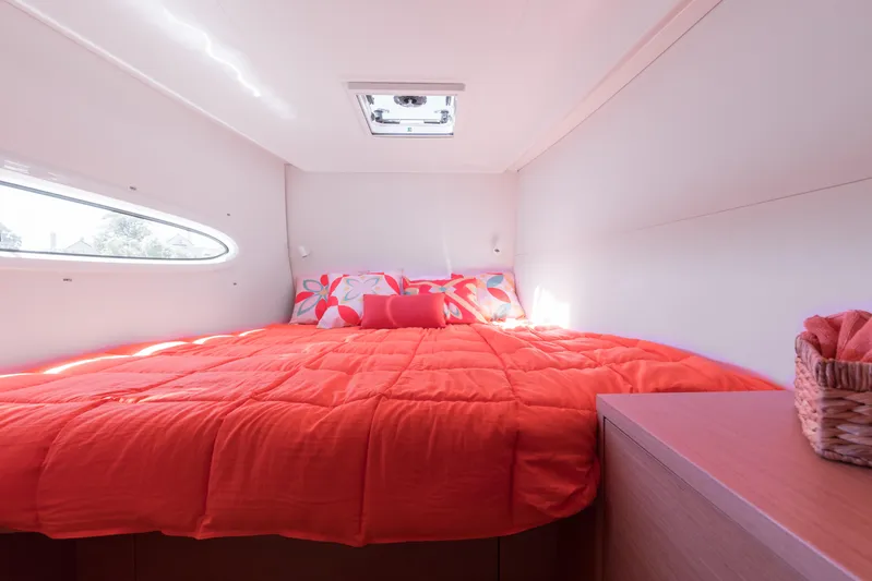 In Stock Yacht Photos Pics Cozy cabin interior of 2024 Excess 14 yacht with vibrant orange bedding.