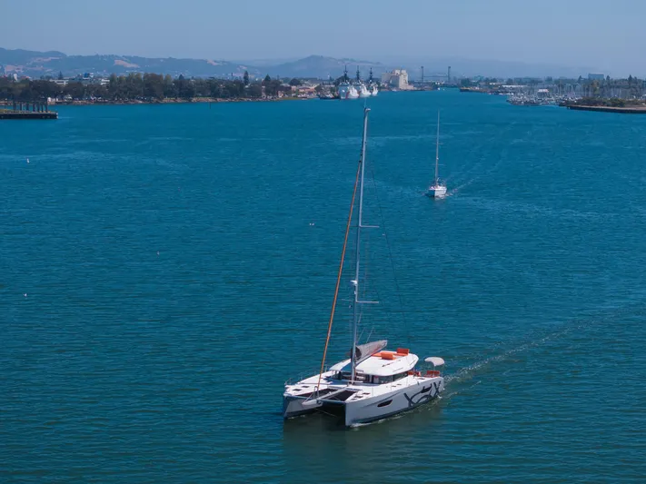 In Stock Yacht Photos Pics 2024 Excess 14 catamaran sailing on a serene blue waterway.