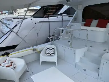  Yacht Photos Pics 2004 Hatteras 70 Enclosed Bridge yacht with white seating and red cushions on deck.