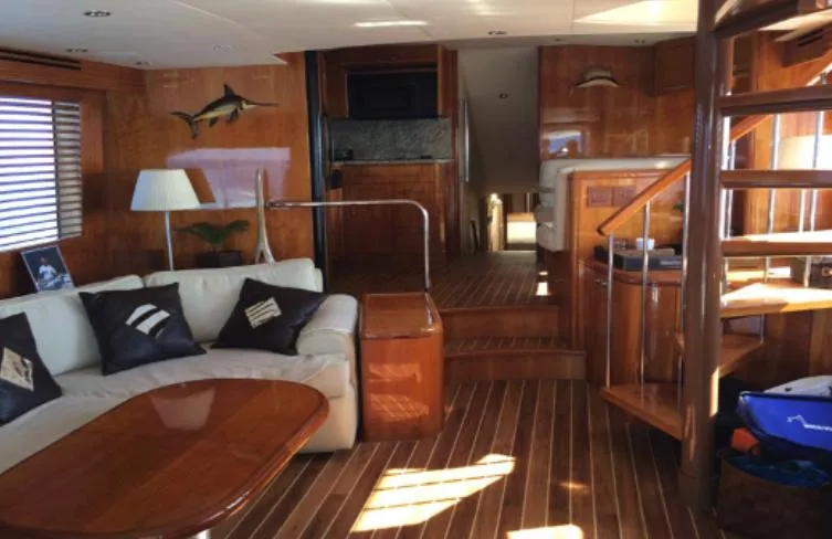  Yacht Photos Pics Luxurious interior of 2004 Hatteras 70 Enclosed Bridge yacht with wooden finishes and cozy seating.