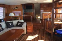 Luxurious interior of 2004 Hatteras 70 Enclosed Bridge yacht with wooden finishes and cozy seating.