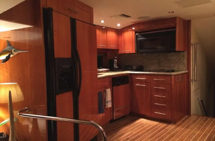  Yacht Photos Pics Luxurious kitchen interior of 2004 Hatteras 70 Enclosed Bridge yacht with wooden cabinetry.