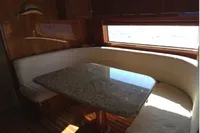 Luxurious dining area in 2004 Hatteras 70 Enclosed Bridge yacht with granite table.