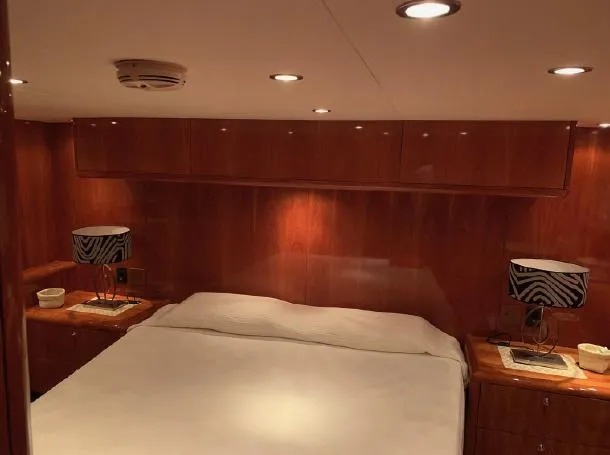  Yacht Photos Pics Luxurious bedroom interior of 2004 Hatteras 70 Enclosed Bridge yacht with wood paneling.