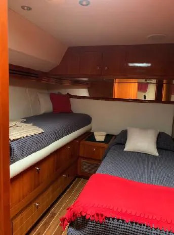  Yacht Photos Pics 2004 Hatteras 70 Enclosed Bridge cabin with twin beds, wood finish, and red accents.