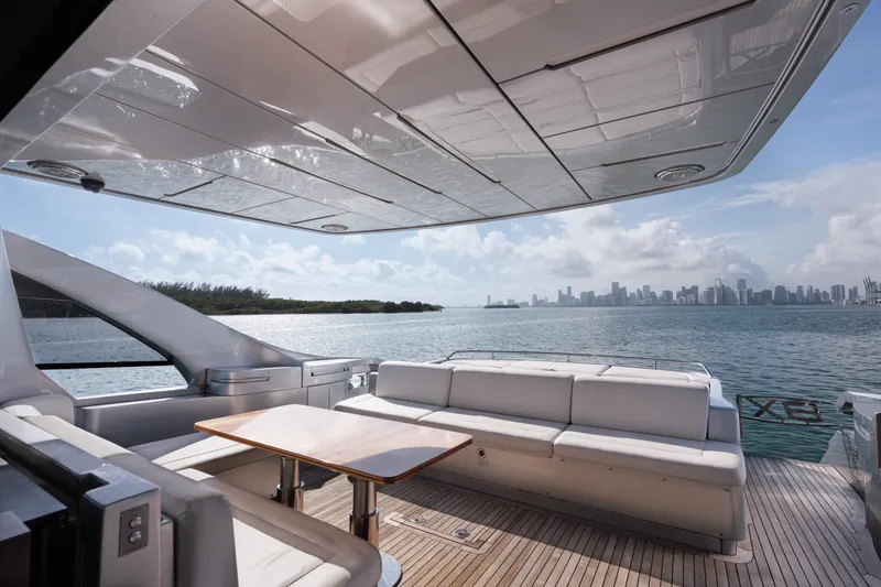 Alexandra Yacht Photos Pics Luxurious 2020 Pershing 8X yacht deck with seating, overlooking a scenic waterfront city skyline.