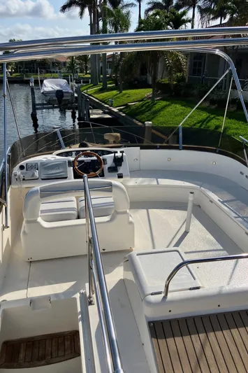 Sea Jeanie Yacht Photos Pics 1999 Viking Princess 52 Express Bridge yacht with spacious deck and helm, docked by palm trees.