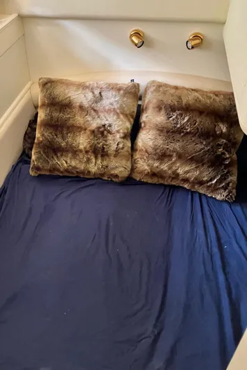 Sea Jeanie Yacht Photos Pics Cozy cabin bed with fur pillows on a 1999 Viking Princess 52 Express Bridge.