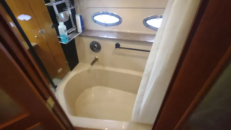  Yacht Photos Pics Luxurious bathroom in 2001 Cruisers Yachts 4450 Express Motoryacht with oval windows and bathtub.