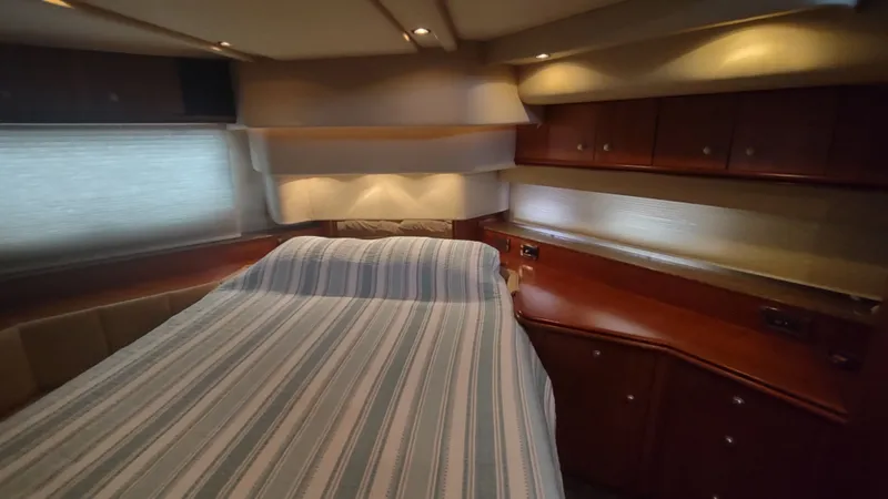  Yacht Photos Pics Interior of 2001 Cruisers Yachts 4450 Express Motoryacht with bed and wooden cabinetry.