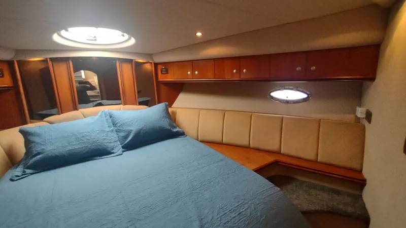  Yacht Photos Pics Luxurious cabin interior of 2001 Cruisers Yachts 4450 Express Motoryacht with cozy bed and porthole.
