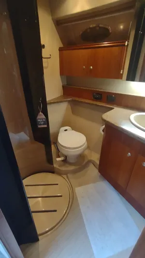  Yacht Photos Pics 2001 Cruisers Yachts 4450 Express Motoryacht bathroom with shower, toilet, and wooden cabinetry.