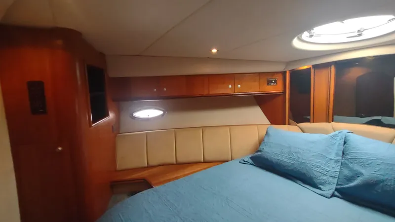  Yacht Photos Pics Luxurious cabin interior of 2001 Cruisers Yachts 4450 Express Motoryacht with blue bedding.