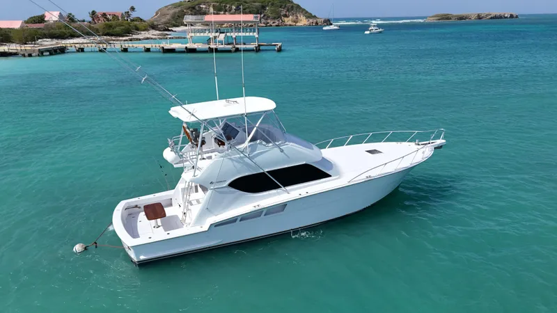  Yacht Photos Pics 2005 Hatteras 50 Convertible yacht in turquoise waters near a dock.