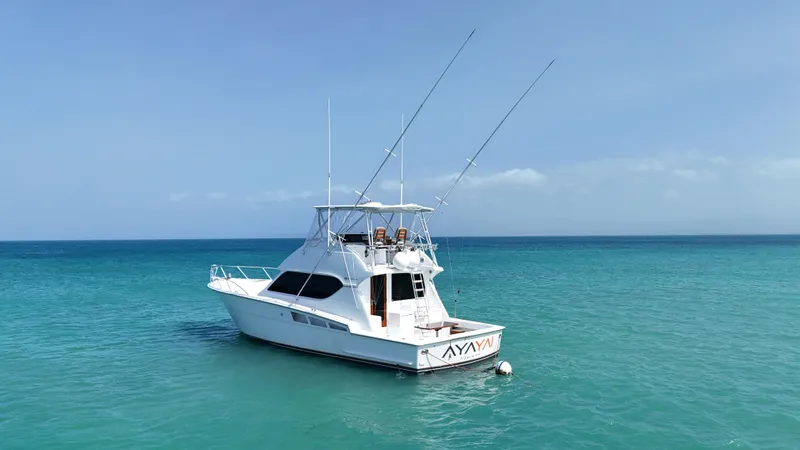  Yacht Photos Pics 2005 Hatteras 50 Convertible yacht anchored in clear blue ocean waters.