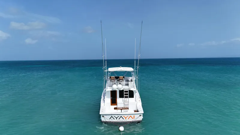  Yacht Photos Pics Hatteras 50 Convertible 2005 yacht on clear blue ocean water, rear view.