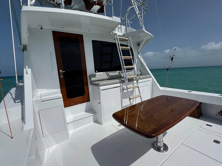  Yacht Photos Pics Hatteras 50 Convertible 2005 yacht deck with wooden table and ladder, ocean view.