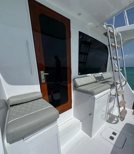  Yacht Photos Pics 2005 Hatteras 50 Convertible yacht with cushioned seating and ladder on deck.