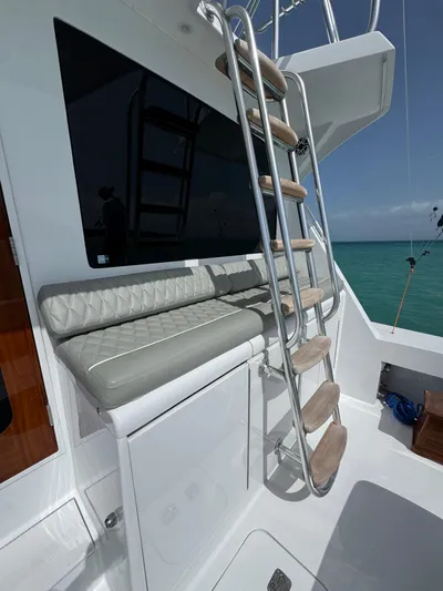  Yacht Photos Pics 2005 Hatteras 50 Convertible yacht with ladder and cushioned seating, overlooking the ocean.