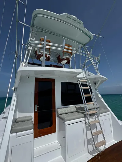  Yacht Photos Pics 2005 Hatteras 50 Convertible yacht with flybridge, ladder, and ocean backdrop.