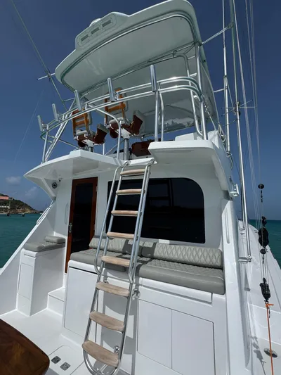  Yacht Photos Pics 2005 Hatteras 50 Convertible yacht with ladder and seating, under clear blue sky.
