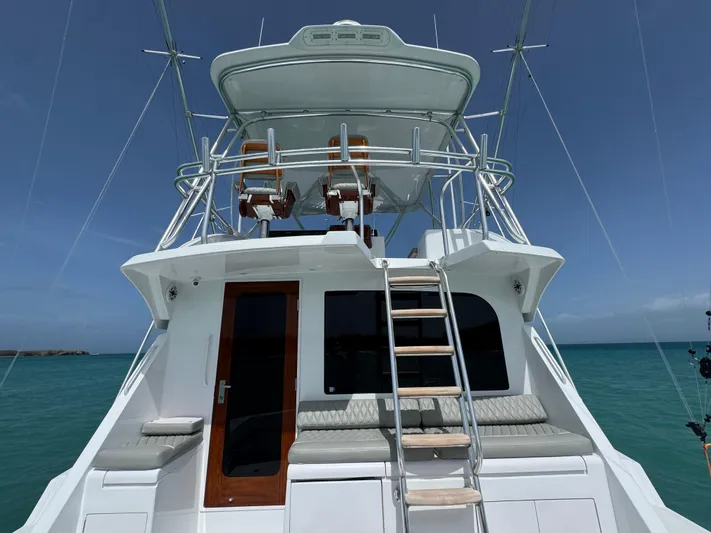  Yacht Photos Pics 2005 Hatteras 50 Convertible yacht with flybridge, ladder, and ocean backdrop.