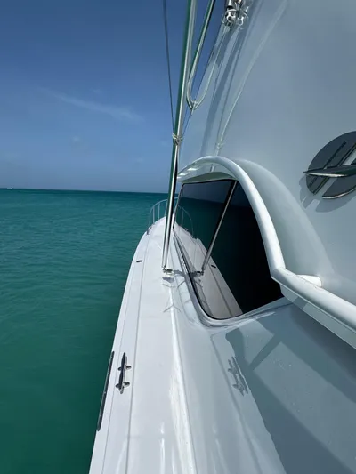  Yacht Photos Pics 2005 Hatteras 50 Convertible yacht on turquoise sea under clear blue sky.