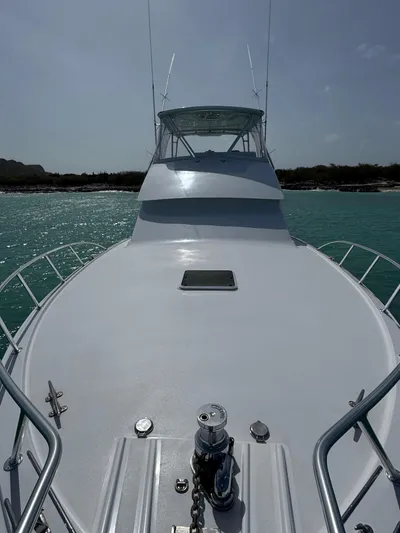  Yacht Photos Pics 2005 Hatteras 50 Convertible yacht on turquoise water, viewed from the bow.