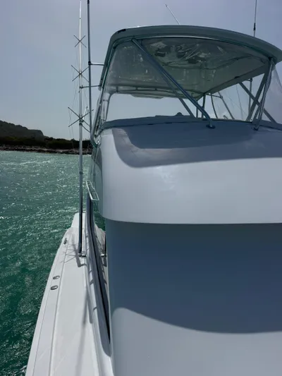  Yacht Photos Pics 2005 Hatteras 50 Convertible yacht on turquoise water, side view.