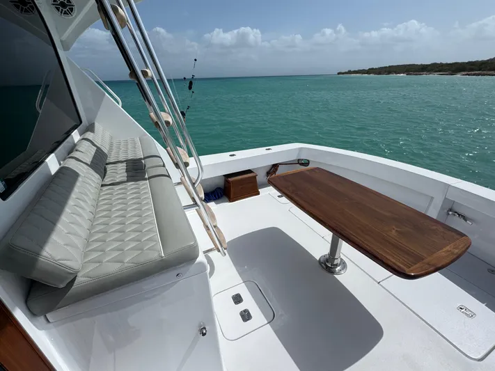  Yacht Photos Pics Hatteras 50 Convertible 2005 yacht deck with seating and table, overlooking turquoise waters.