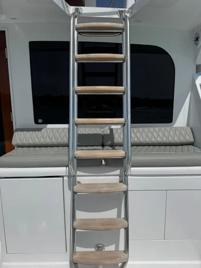  Yacht Photos Pics Ladder on 2005 Hatteras 50 Convertible yacht with cushioned seating and sleek design.