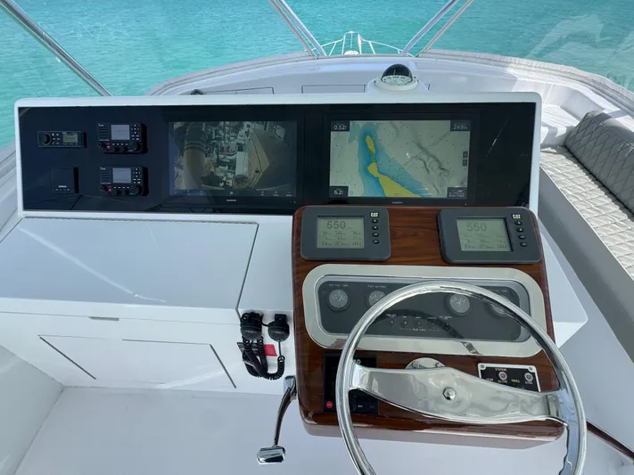  Yacht Photos Pics Helm of 2005 Hatteras 50 Convertible yacht with navigation screens and steering wheel.