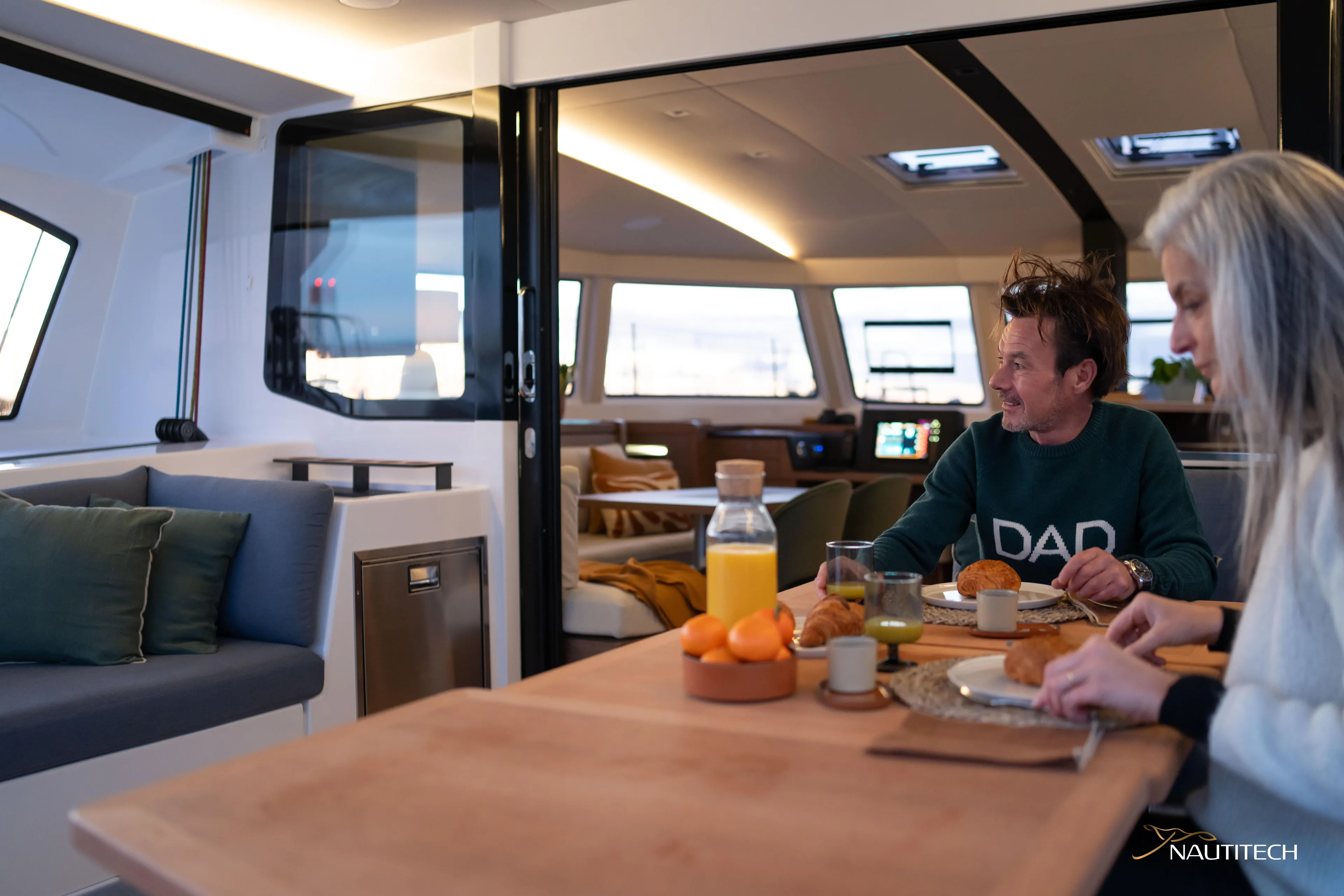 Nautitech 48 Open - Available For 2026 Delivery! Yacht Photos Pics Couple enjoying breakfast on Nautitech 48 Open yacht, 2026 model, with modern interior design.