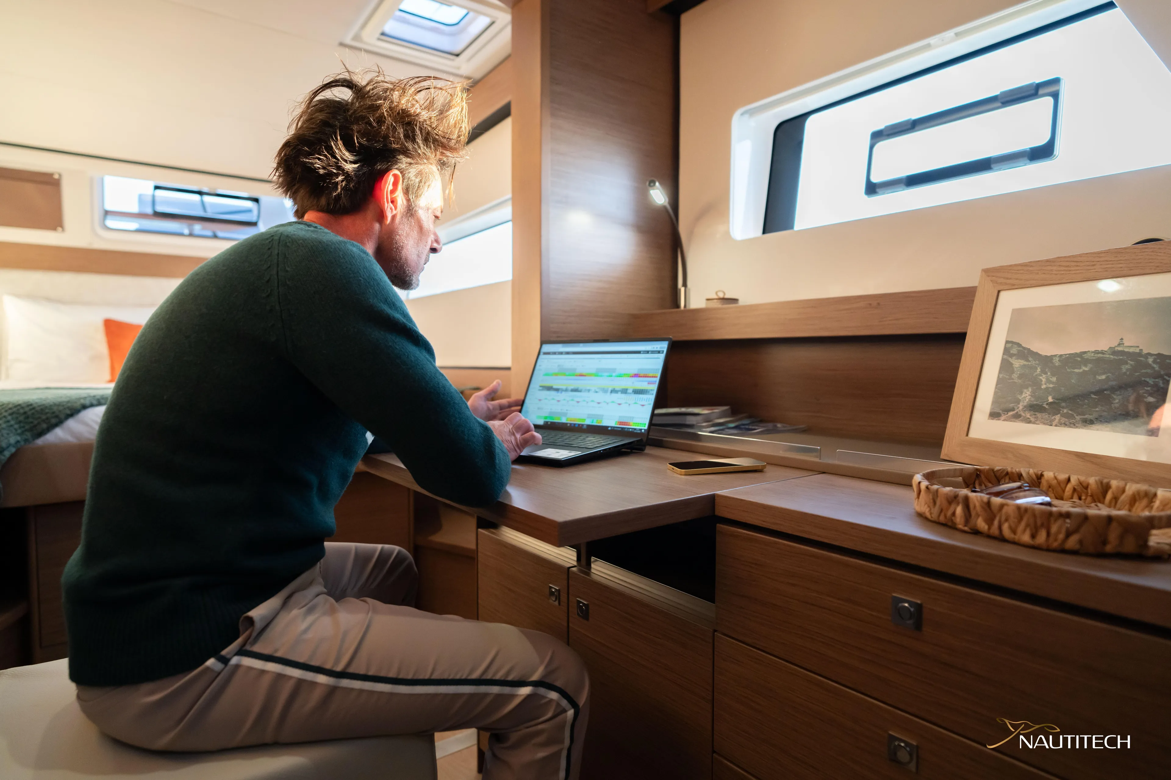 Nautitech 48 Open - Available For 2026 Delivery! Yacht Photos Pics Man working on a laptop inside Nautitech 48 Open (2025) yacht cabin, 2026 model.