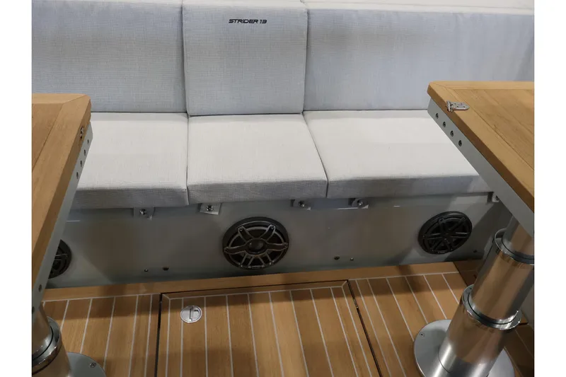  Yacht Photos Pics Luxury seating area on 2026 SACS Strider 13 boat with wooden tables and speakers.