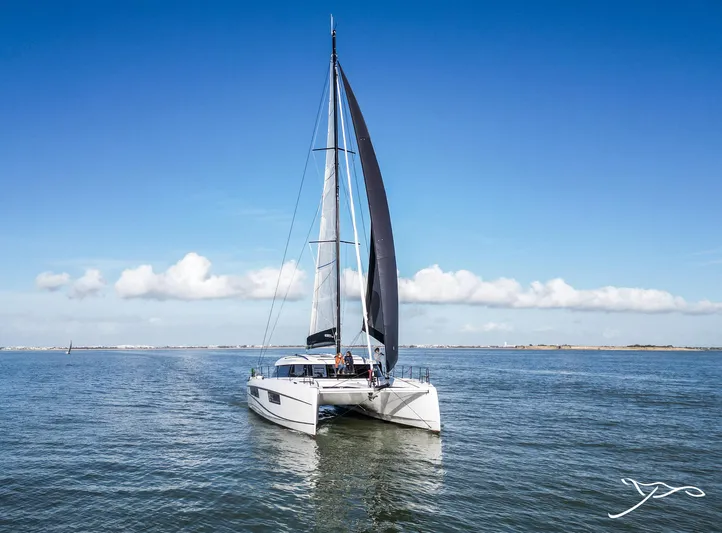 Nautitech 48 Open - Available For 2026 Delivery! Yacht Photos Pics Sailing catamaran Nautitech 48 Open (2025) on calm sea under clear blue sky.
