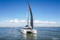 Sailing catamaran Nautitech 48 Open (2025) on calm sea under clear blue sky.