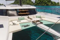 Luxurious Nautitech 48 Open yacht with spacious deck, surrounded by turquoise waters and lush greenery.
