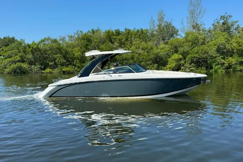  Yacht Photos Pics 2020 Cobalt R30 boat cruising on a calm river with lush greenery.