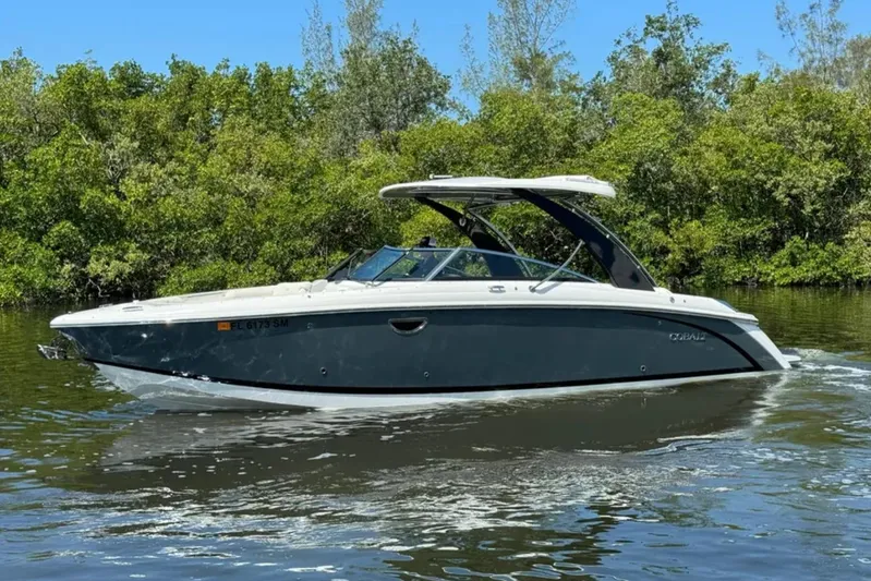  Yacht Photos Pics 2020 Cobalt R30 boat cruising on a calm river with lush greenery.