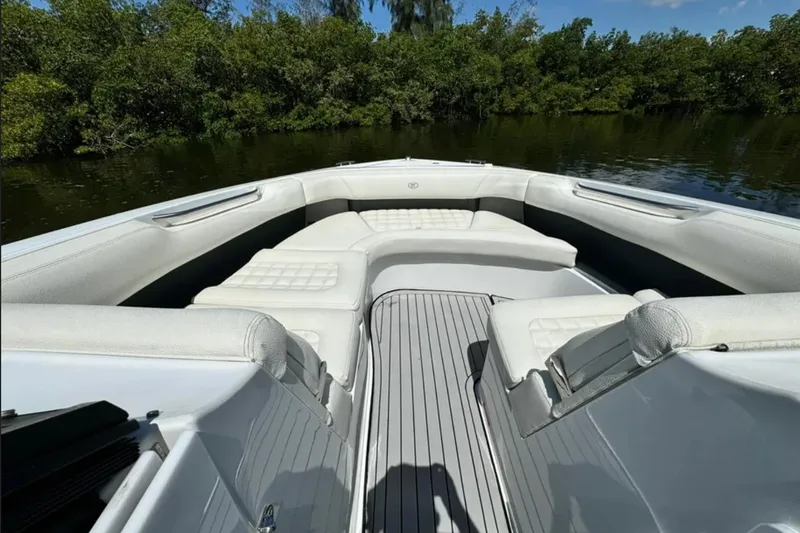  Yacht Photos Pics 2020 Cobalt R30 boat interior with white seating, surrounded by lush greenery.