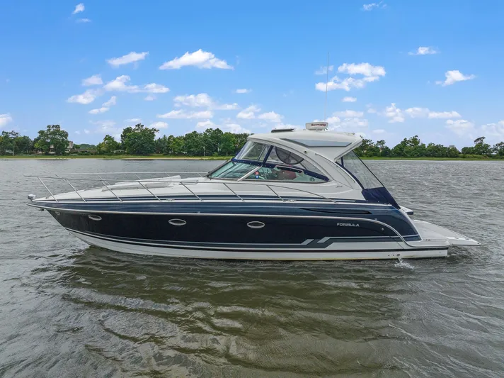  Yacht Photos Pics 2020 Formula 37 PC luxury yacht cruising on a lake under a clear blue sky.