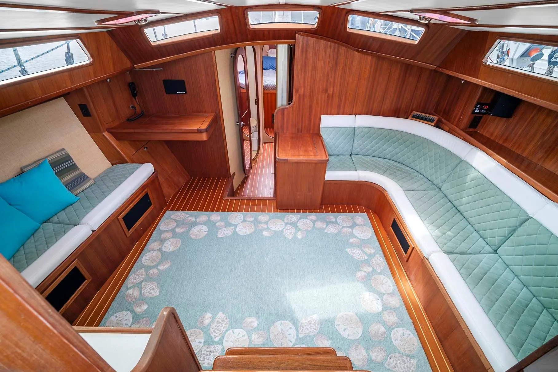 Interior of 1981 Pearson 530 yacht with wooden finish and cozy seating area.