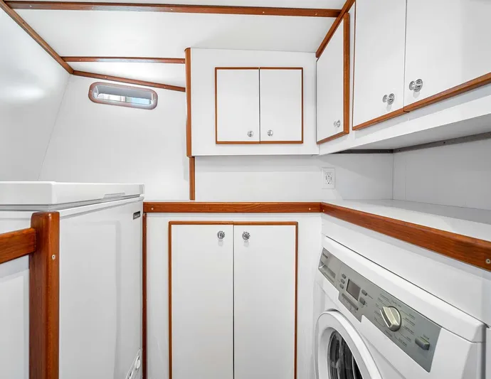 Best Revenge Yacht Photos Pics Laundry area in 1981 Pearson 530 yacht with white cabinets and wood trim.