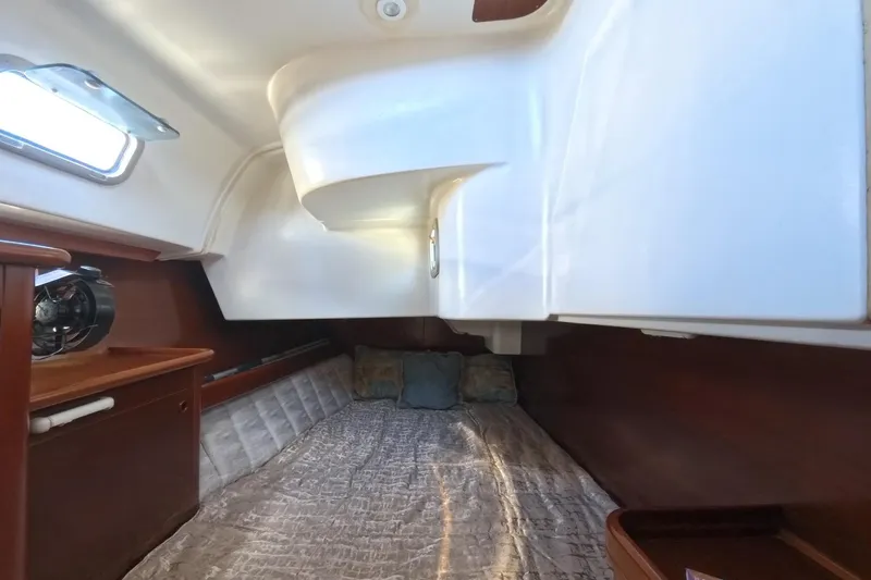 Prime Directive Yacht Photos Pics Cozy cabin interior of 1999 Beneteau Oceanis 461 sailboat with bed and wooden accents.