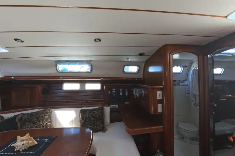 Prime Directive Yacht Photos Pics Interior of 1999 Beneteau Oceanis 461 yacht with wooden furnishings and cozy seating area.