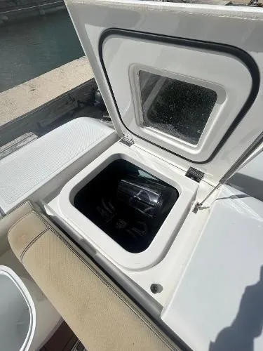 No Name Yacht Photos Pics 2019 Pursuit OS 385 Offshore boat storage compartment with open hatch, dockside view.