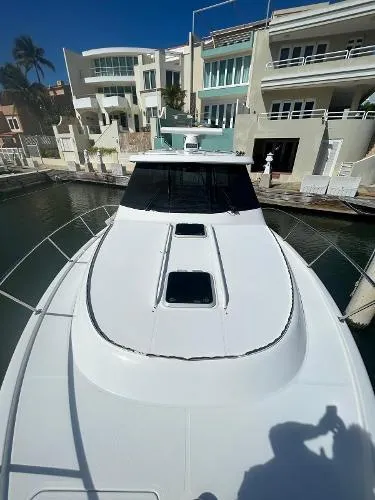 No Name Yacht Photos Pics 2019 Pursuit OS 385 Offshore boat docked near modern waterfront homes.
